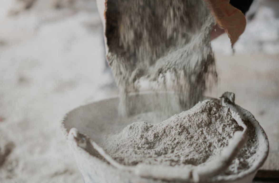 Cement powder being poured into a bucket for home quality test